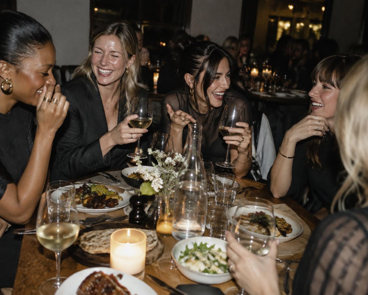 Women laughing together over dinner